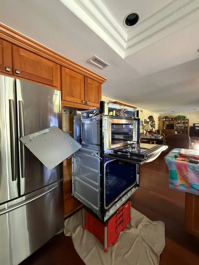 Built-in oven repair with cabinets and fridge nearby